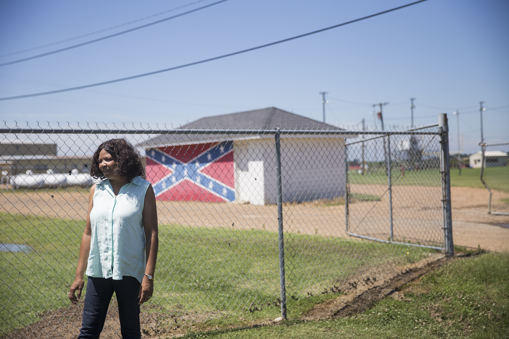 Gloria Dickerson stands in front of a shed at North Sunflower Academy, a private school where many white students enrolled after integration. Today the academy is the town’s only high school, but enrolls white students almost exclusively. (Natalie Griffin/News21) 