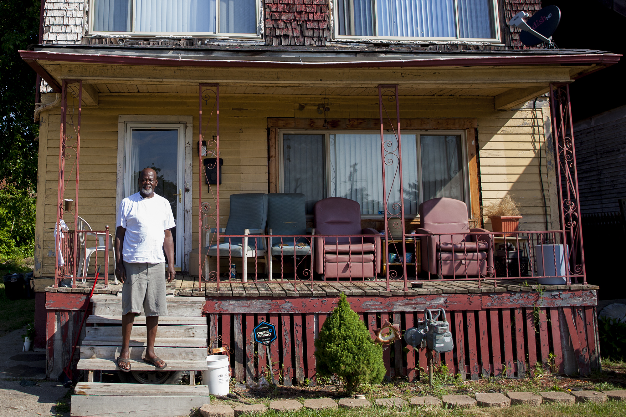 Richard Cooper stands on his front porch in Highland Park, Michigan, across from an empty lot where his elementary school once stood. (Photo by Jeffrey Pierre, audio by Lily Altavena/News21)