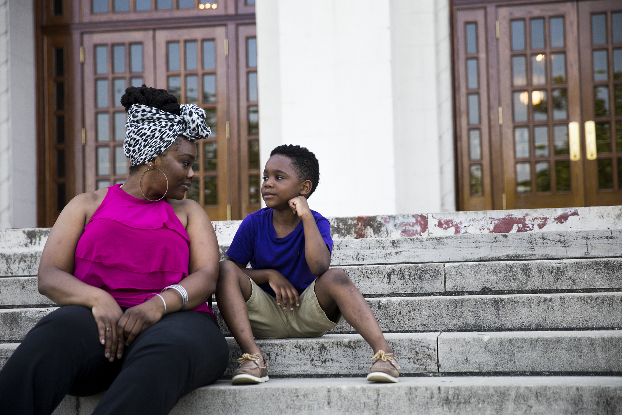 Isis Pettway and her son Caleb sit on the steps of historic Little Rock Central High School, one of the 48 Little Rock schools that Arkansas took control of in 2015. Pettway graduated from the school in 2000 and now sends her 7-year-old son to one of the city’s elementary schools. (Natalie Griffin/News21)