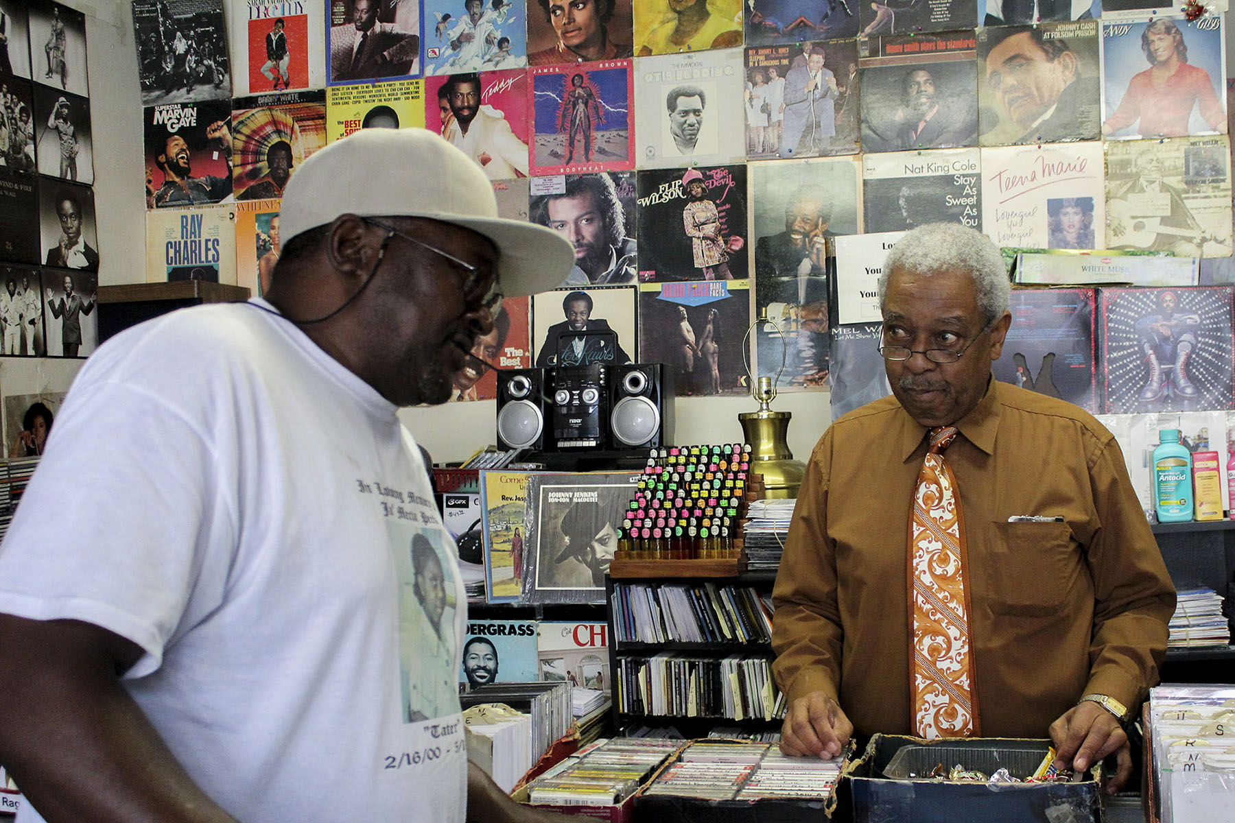 Lafayette Haynes helps a customer at Lafayette Old School Music Store, which he owns. During the civil rights era, Macon was a hub for both black businesses and entertainers, including Little Richard and Otis Redding. Consolidation reduced black influence in the area, Ficklin said. (Phillip Jackson/News21)