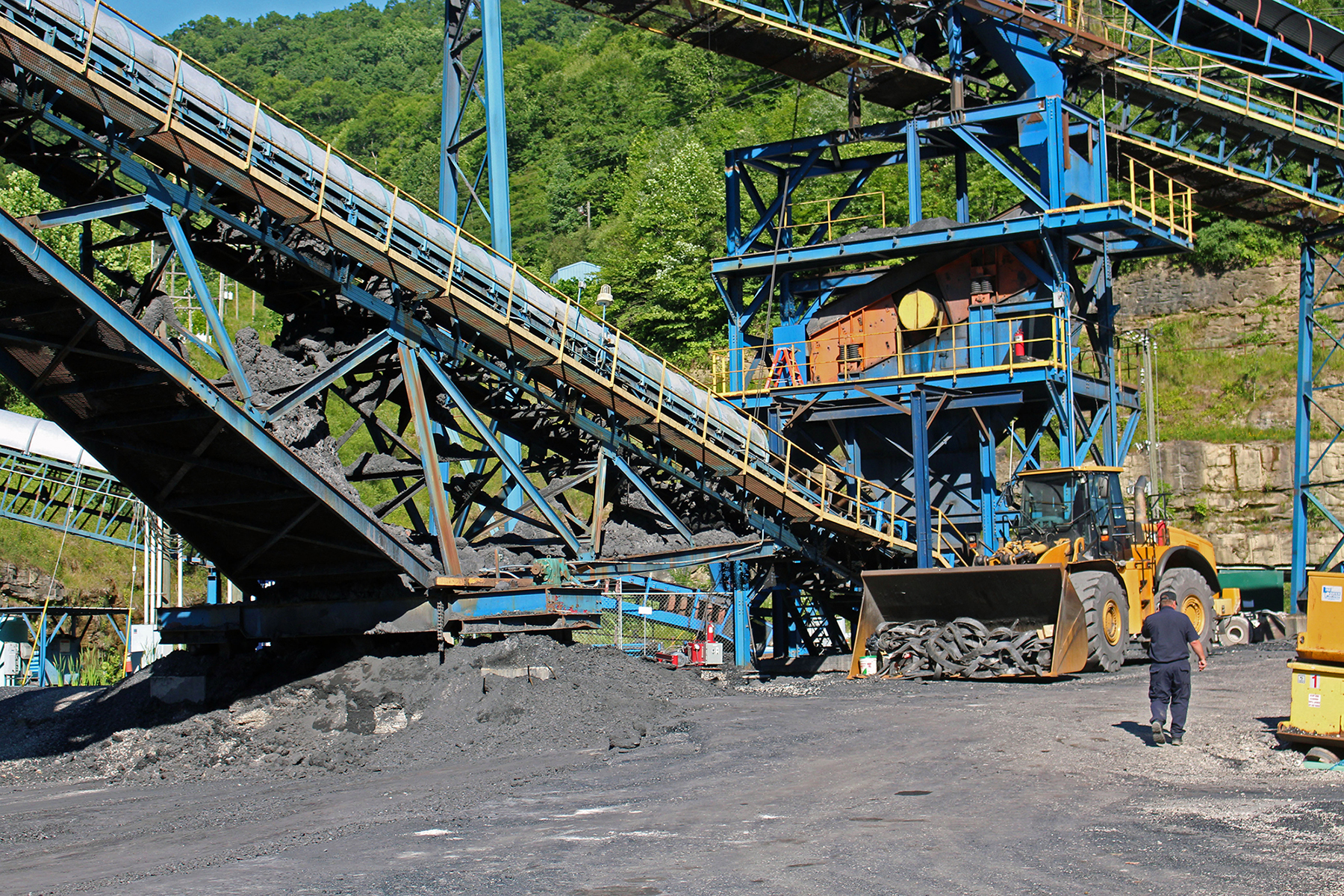 A security guard walks past coal mining equipment at Enterprise Mining Co. in Redfox, Kentucky. The mine went idle in July because of a lack of sales. (Emily Mills/News21)