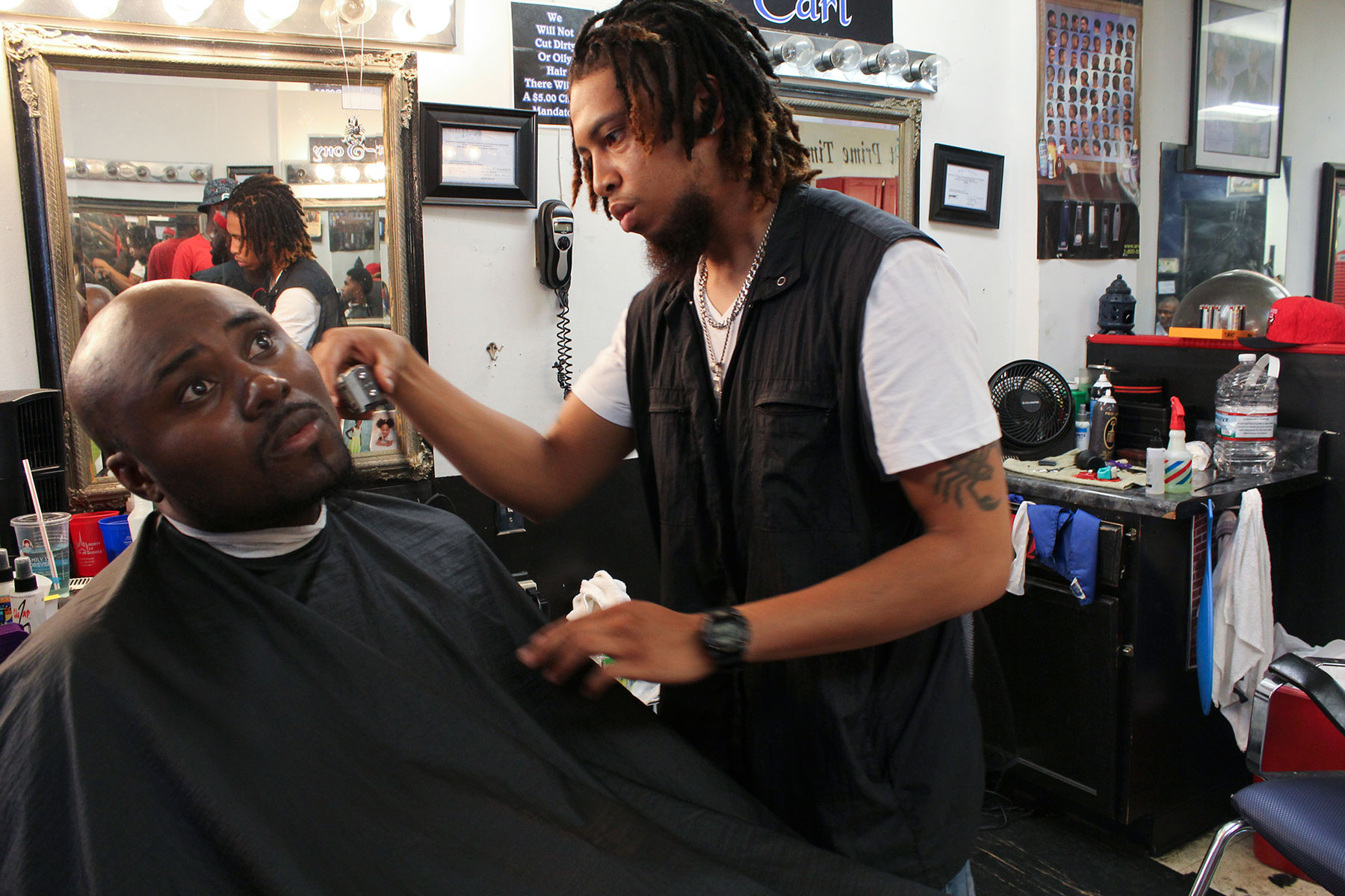 Prime Time Barbershop is the place where Michael Brown used to get his hair cut. Brandon Turner, shown here, worked at the barbershop when Brown’s death happened. He still believes the city needs to do better on police relations. (Phillip Jackson/News21)